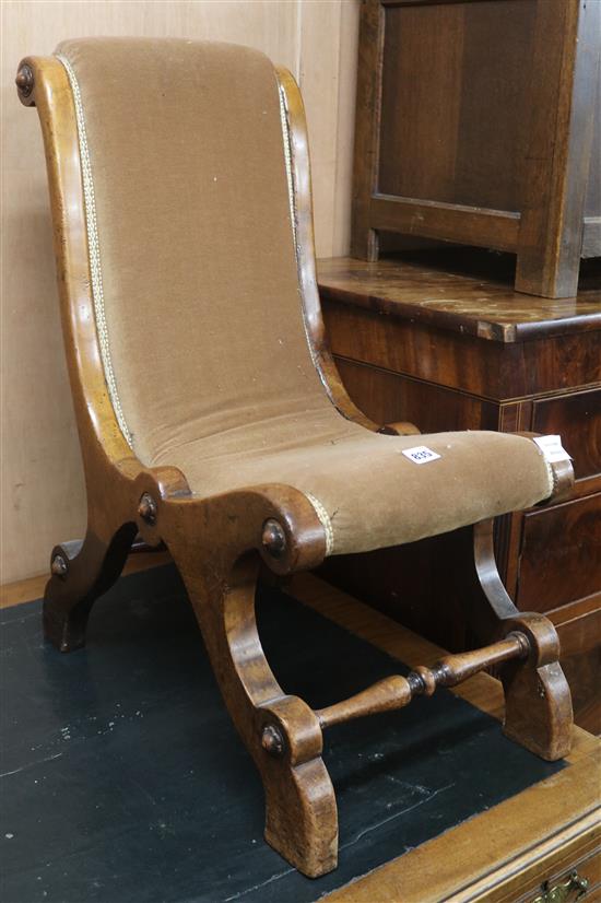 An early walnut Victorian nursing chair, with scrolling padded back and seat